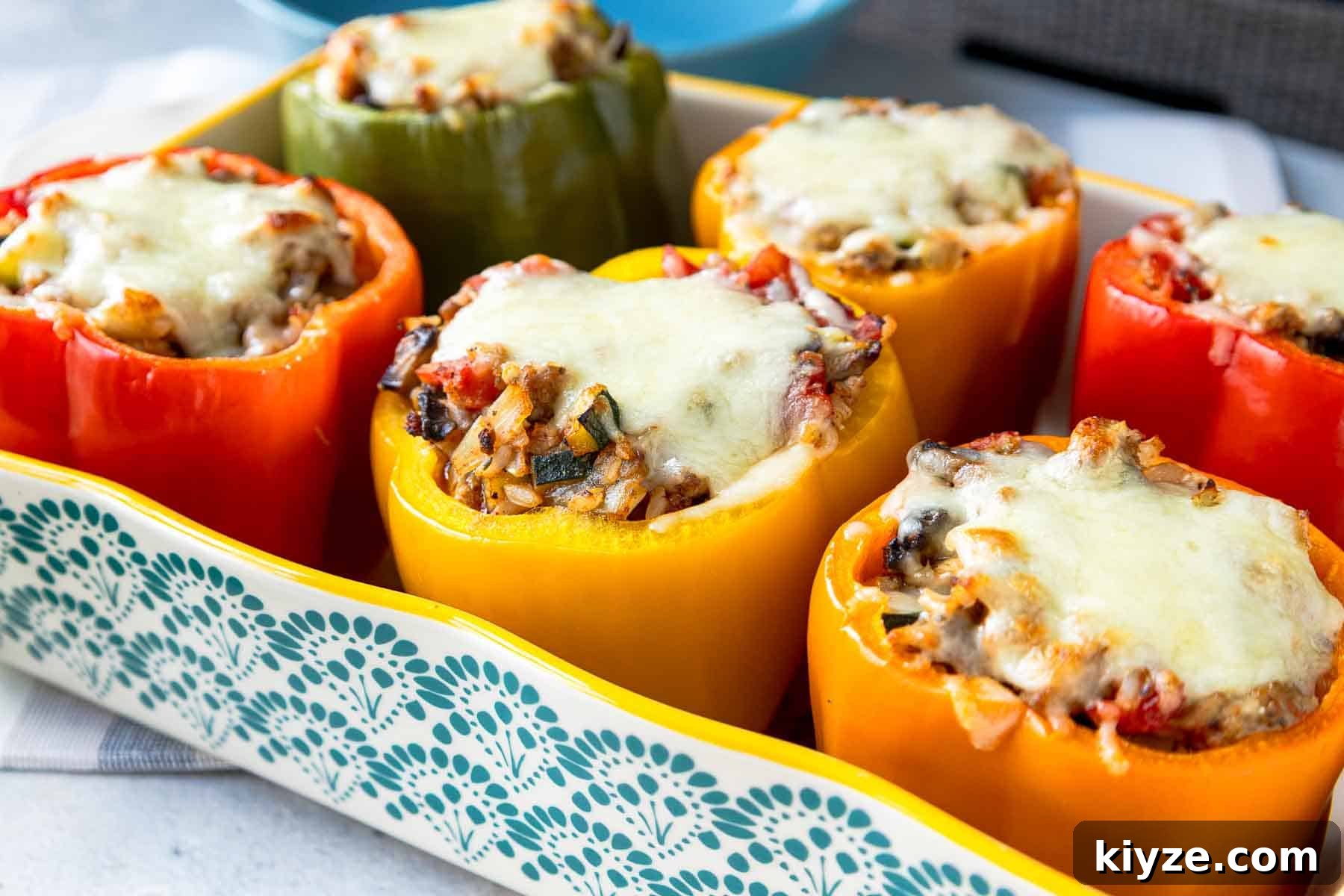 Ground Turkey and Rice Stuffed Bell Peppers Recipe 14 Baking dish with six multicolored stuffed bell peppers standing upright topped with melted mozzarella cheese