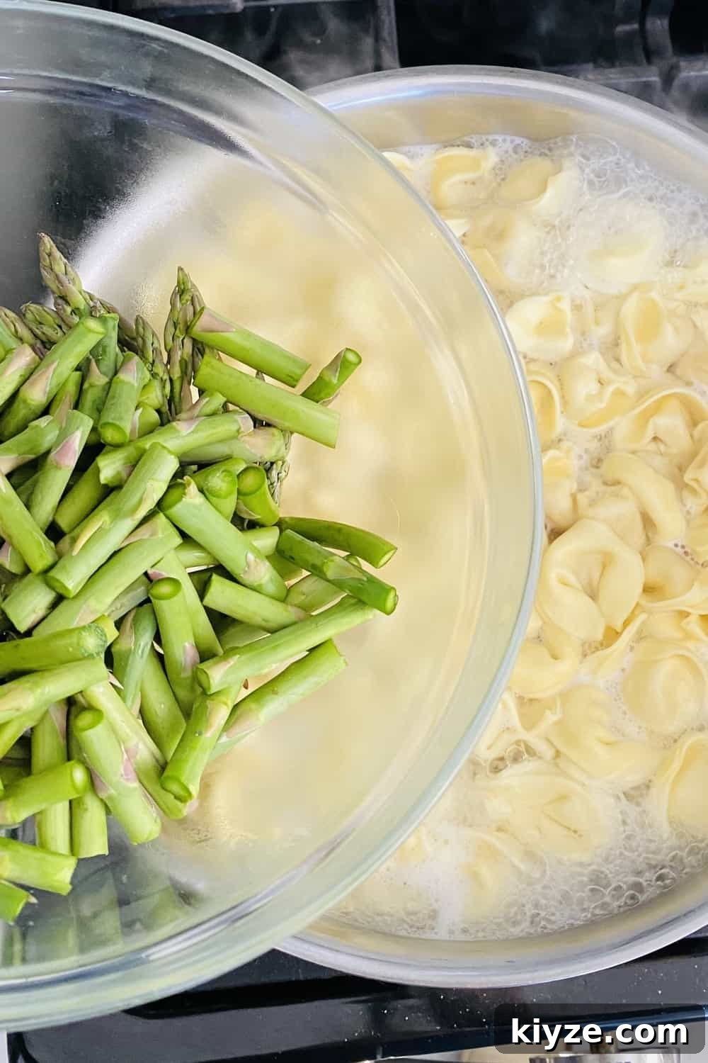 adding asparagus to cooking tortellini pasta