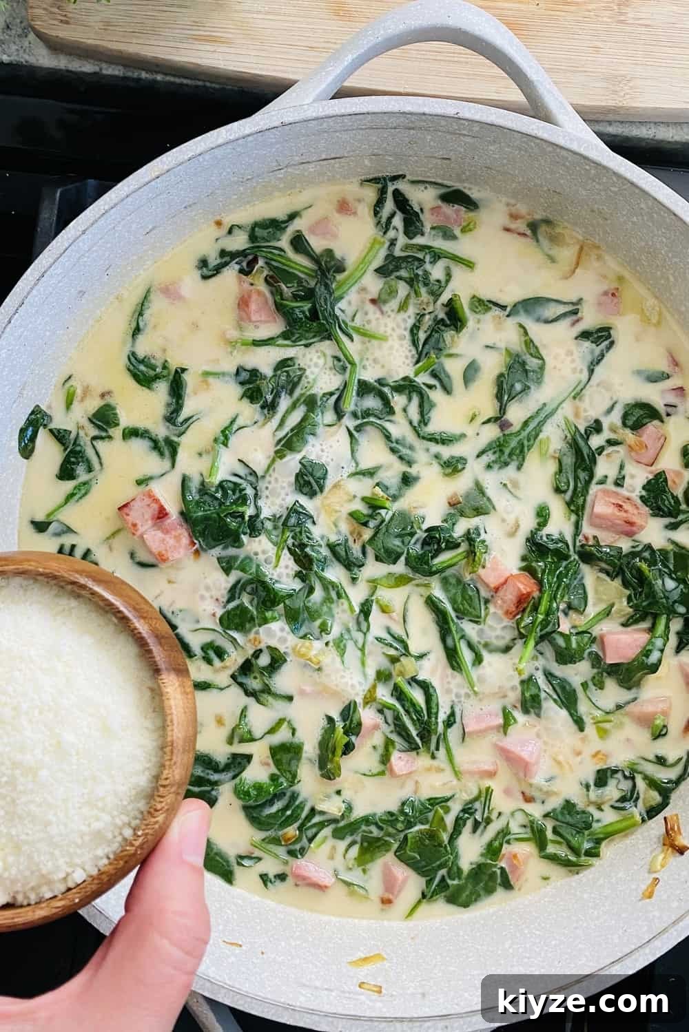 adding Parmesan cheese to sauce