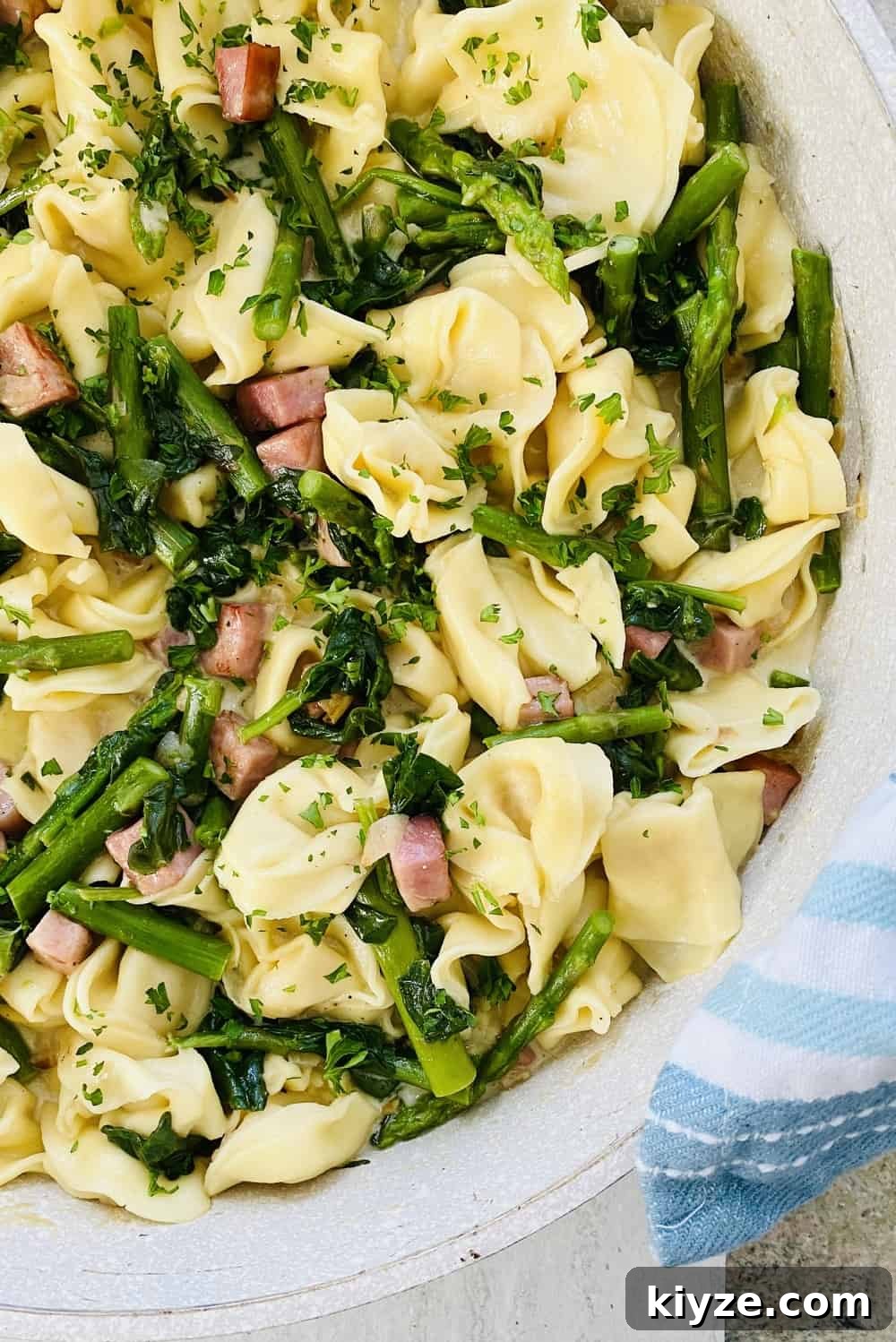 cheese tortellini pasta with sauteed ham, asparagus and spinach