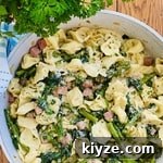 tortellini in a sauté pan with sauteed ham, spinach and asparagus