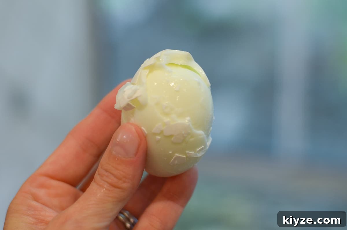 How to Make Hard-Boiled Eggs That Peel Perfectly 3 A hand holding a poorly peeled egg.