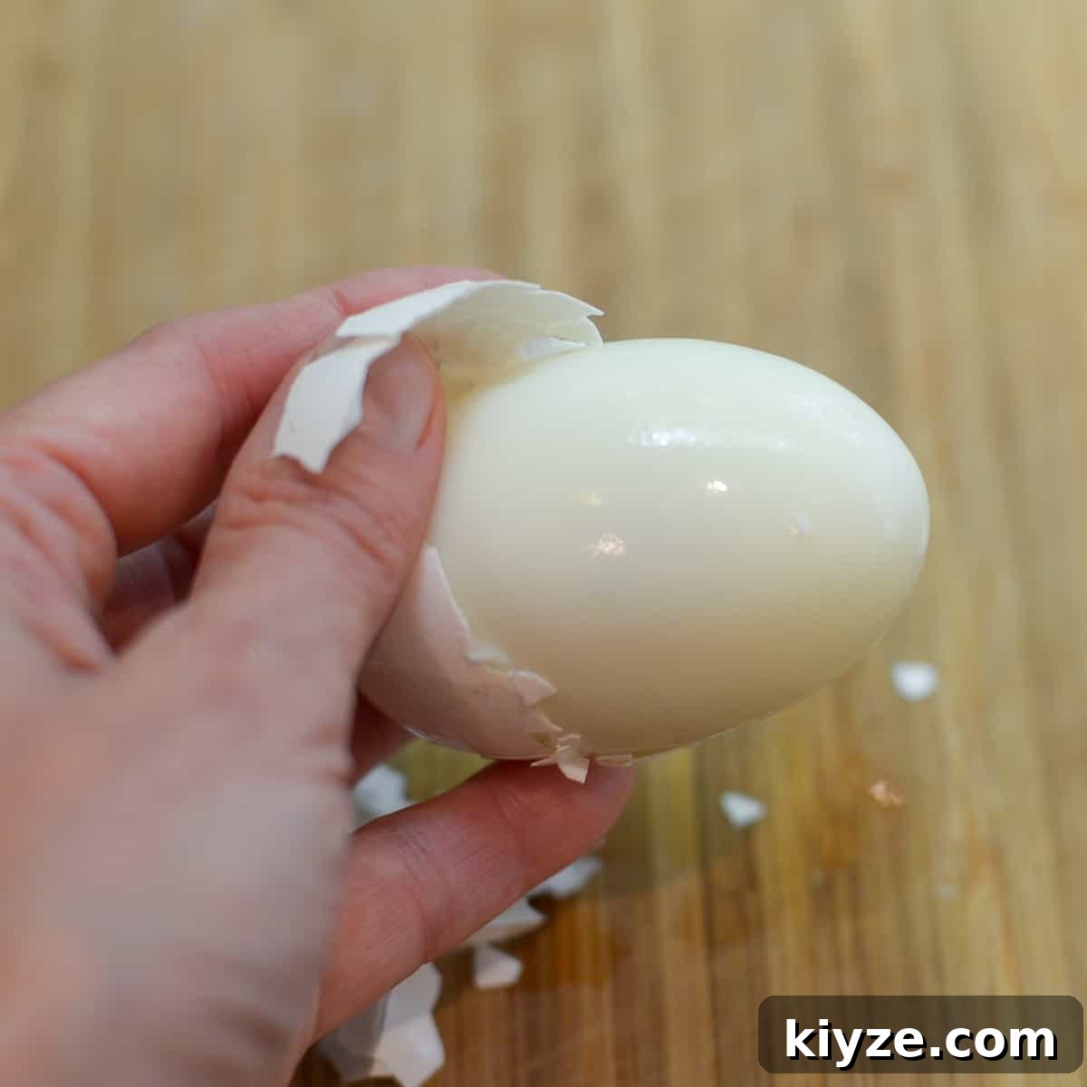 How to Make Hard-Boiled Eggs That Peel Perfectly 7 A hand pulls the shell away from a hard boiled egg.