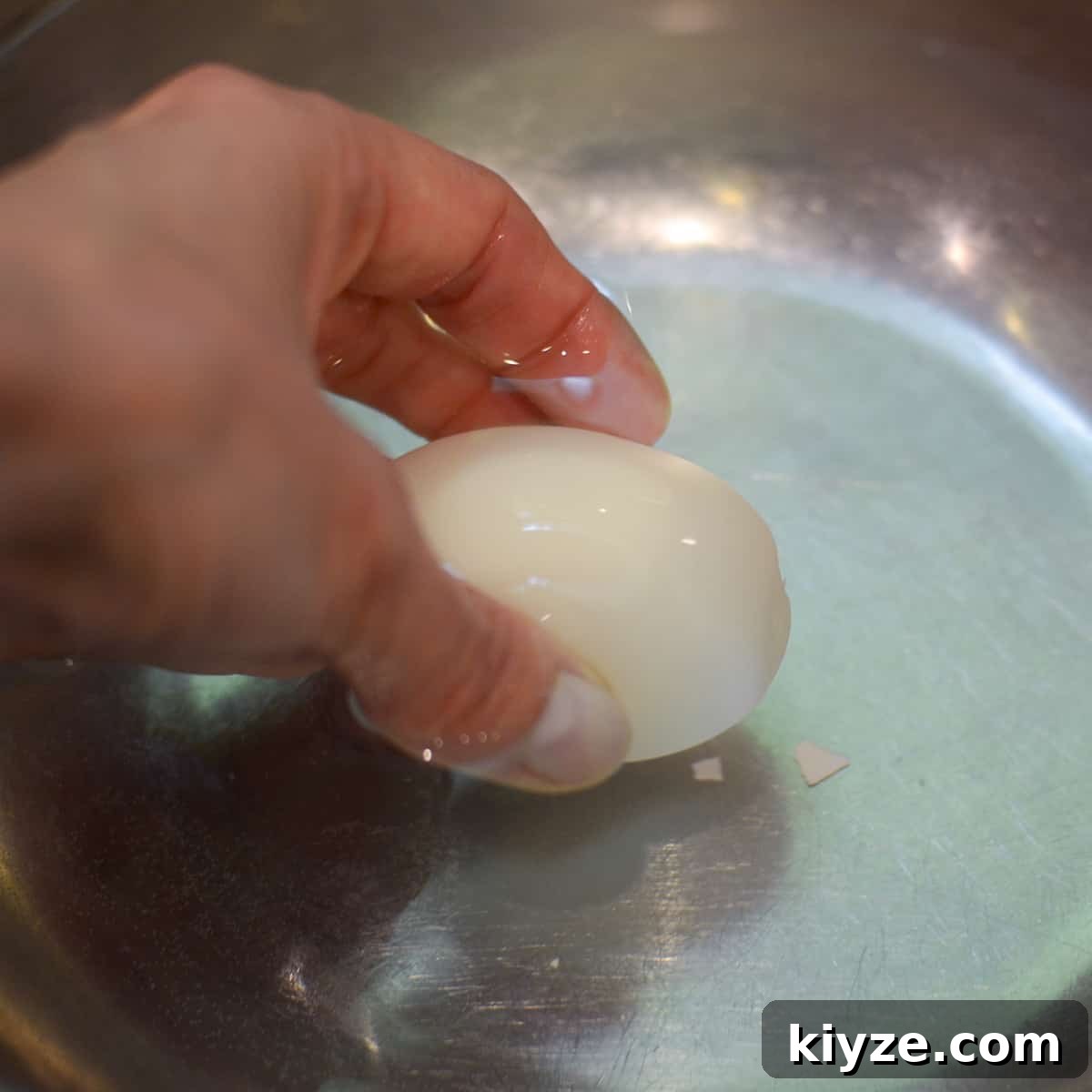 How to Make Hard-Boiled Eggs That Peel Perfectly 9 A hand dipping a peeled egg into a bowl of water.