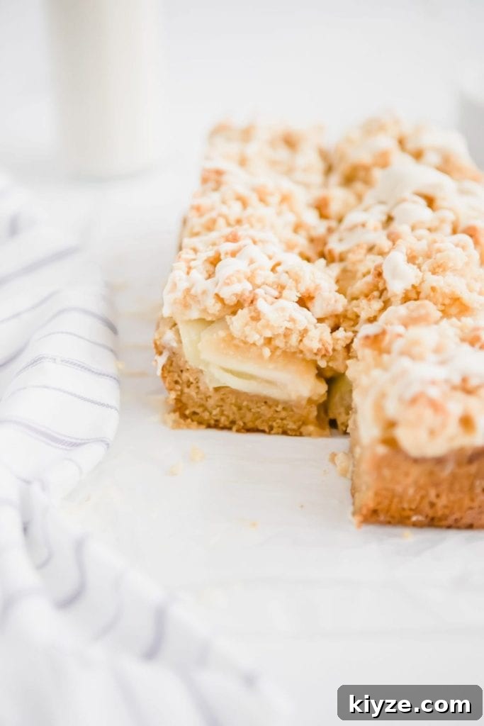 apple crumb coffee cake with cinnamon streusel and vanilla icing recipe on parchment paper