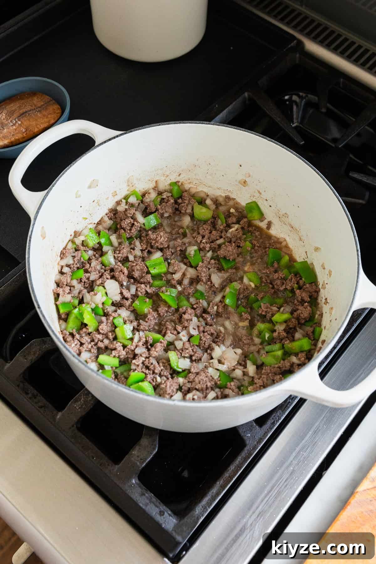 Classic American Chop Suey with Ground Beef Recipe 4 Cooking ground beef, green bell peppers, onions and garlic in a large pot.