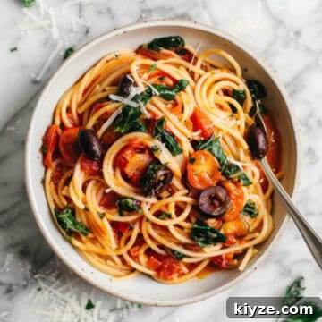 Aldi Weekly Meal Plan for £25 – Week 4 Shopping & Recipes 6 Easy anchovy tomato pasta puttanesca style in a white bowl with olives and herbs.