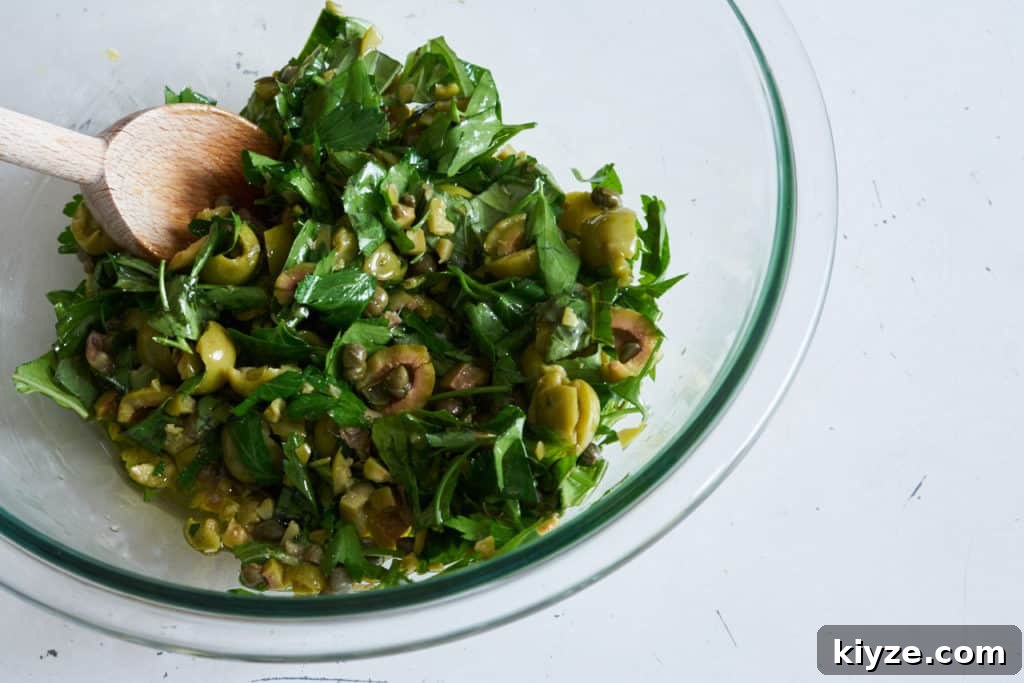 Pasta with Green Olives, Capers & Fresh Herbs Recipe 6 Linguine with green olives, herbs, capers and breadcrumbs in a white bowl.