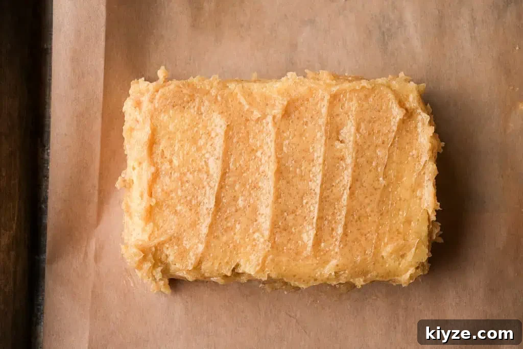 a thick slice of bread slathered with a honey butter sugar mixture on a parchment lined baking sheet