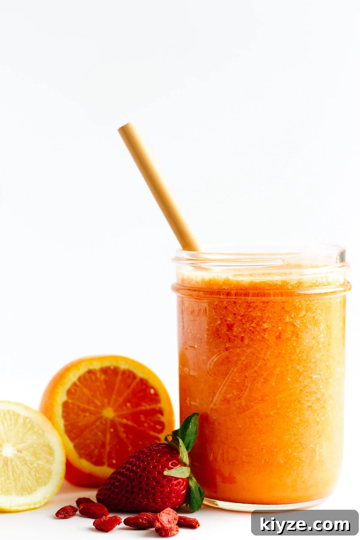 High-Vitamin C Immunity-Boost Smoothie Recipe 4 Smoothie in mason jar with bamboo straw with fruit sitting next to it.