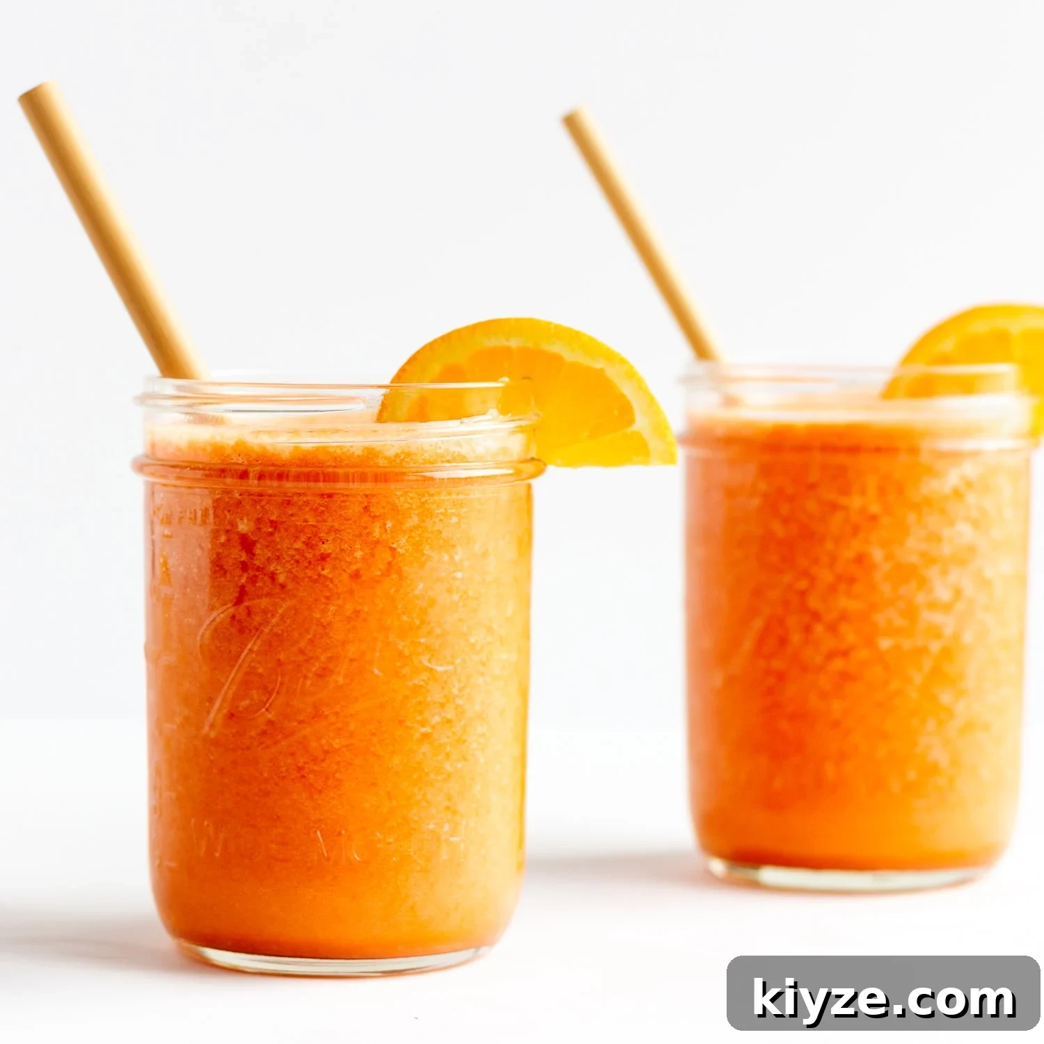 High-Vitamin C Immunity-Boost Smoothie Recipe 7 Two mason jars filled with Vitamin C Immune Boosting Smoothie and garnished with orange slices and a bamboo straw.