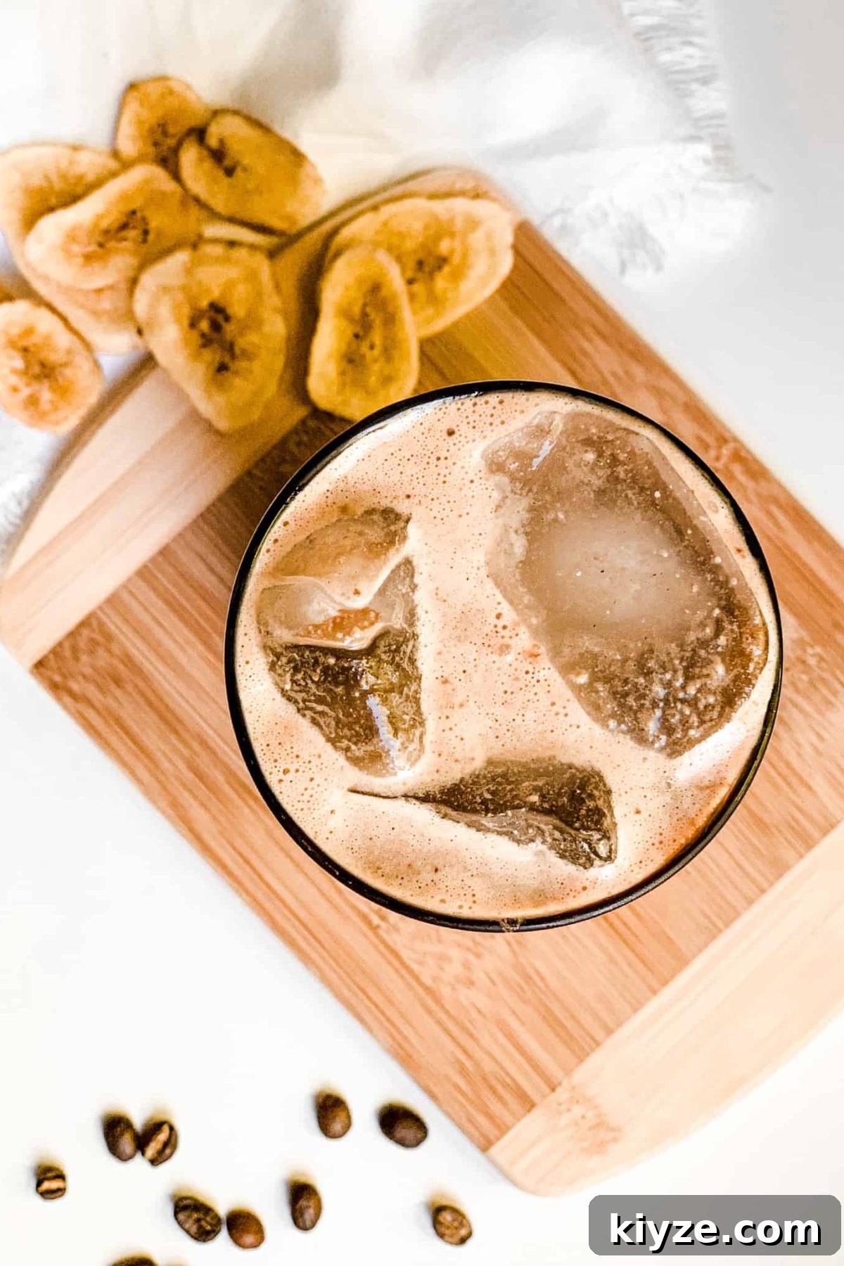 Creamy Iced Coffee Protein Smoothie Creamy Banana Coffee Smoothie in a Tall Glass with Coffee Beans and Sliced Bananas for Food Photography