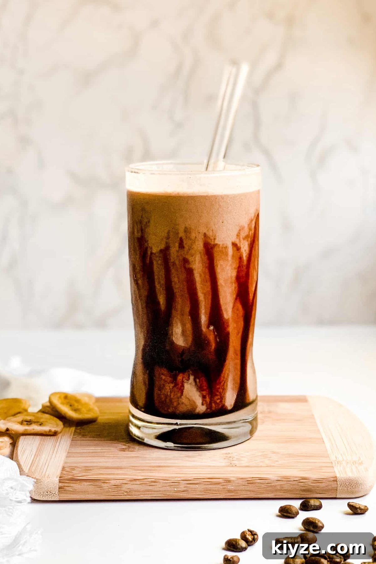 Iced Coffee Protein Smoothie with Date Syrup Creamy Banana Coffee Smoothie in a Tall Glass with Coffee Beans and Sliced Bananas for Food Photography
