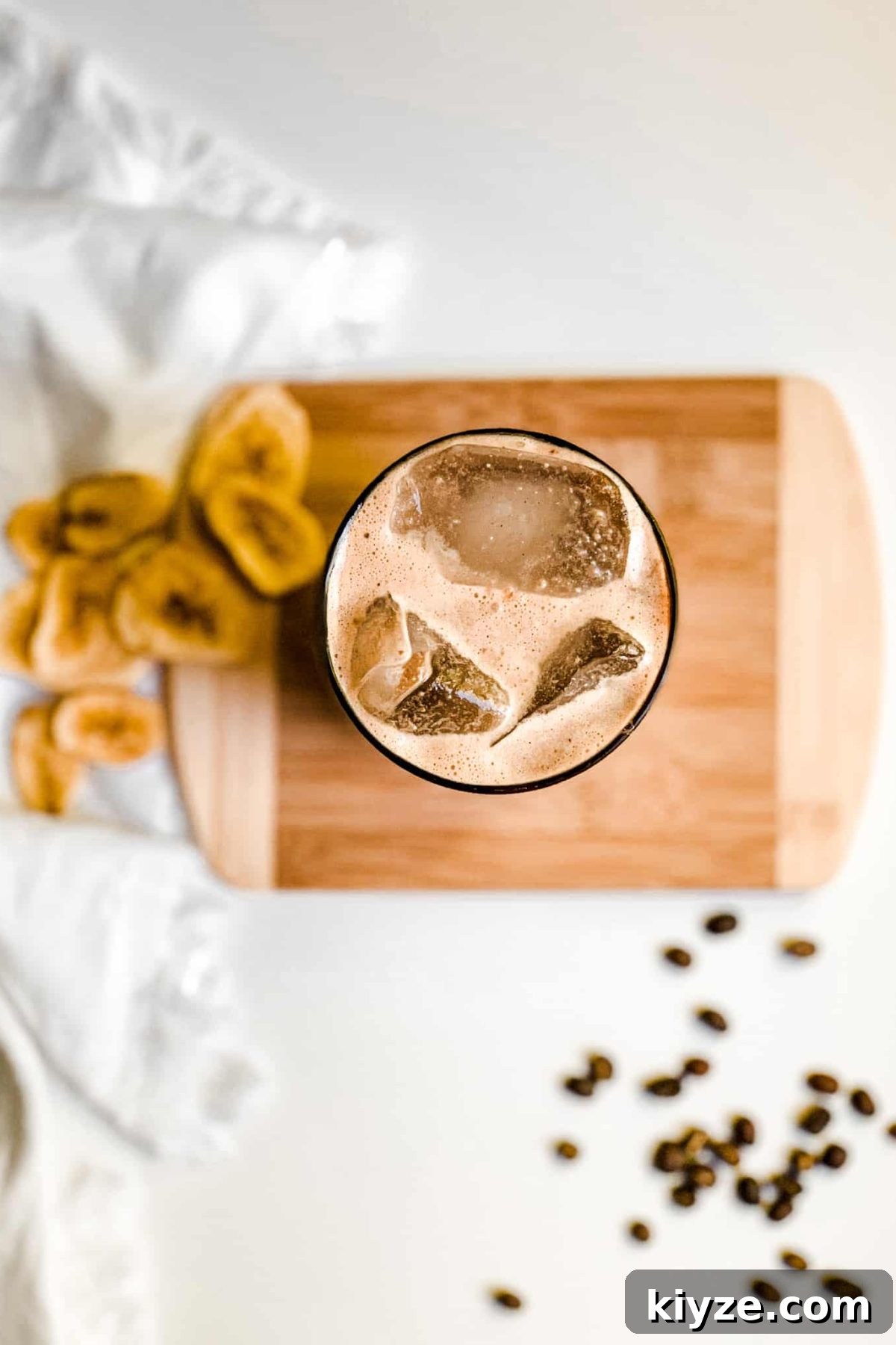 Iced Coffee Protein Smoothie Creamy Banana Coffee Smoothie in a Tall Glass with Coffee Beans and Sliced Bananas for Food Photography