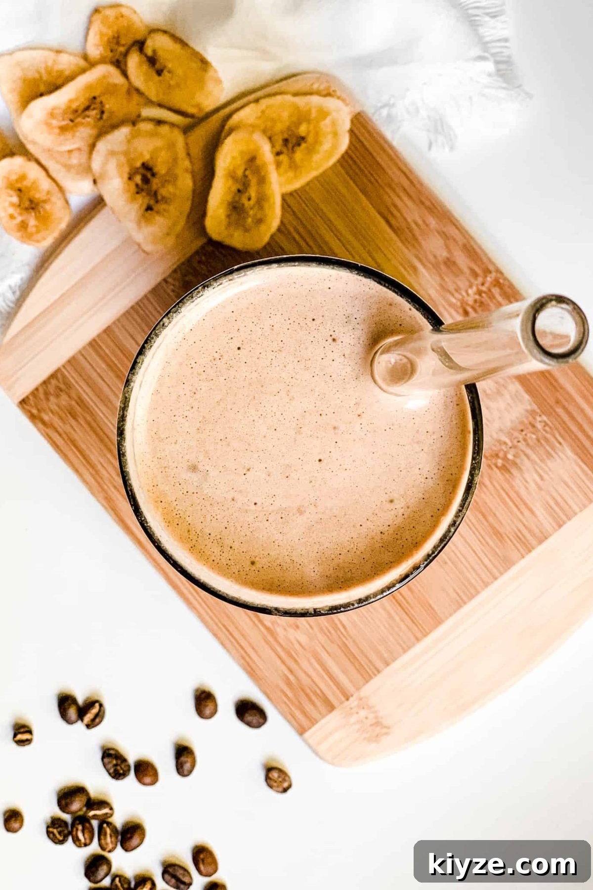 Healthy Iced Coffee Protein Smoothie Creamy Banana Coffee Smoothie in a Tall Glass with Coffee Beans and Sliced Bananas for Food Photography