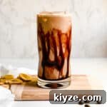 Creamy Banana Coffee Smoothie in a Tall Glass with Coffee Beans and Sliced Bananas for Food Photography