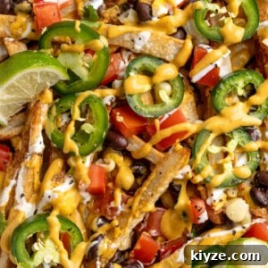 Loaded Nacho Fries Recipe: Crispy Fries with Cheese & Toppings 2 Overhead view of loaded nacho fries topped with vegan queso