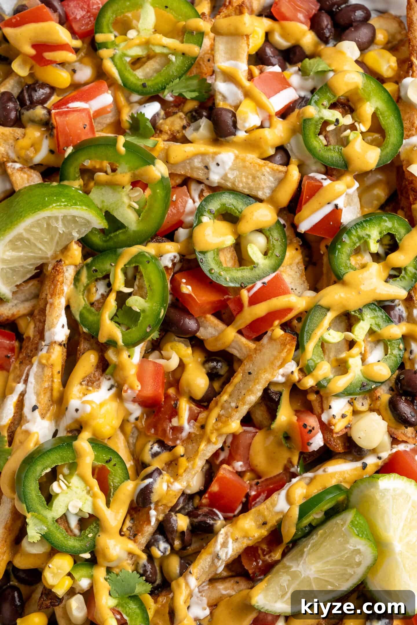 Get the party started with loaded nacho fries! They're topped with all your favourite nacho toppings to create an irresistible appetizer. Overhead view of loaded nacho fries topped with vegan queso