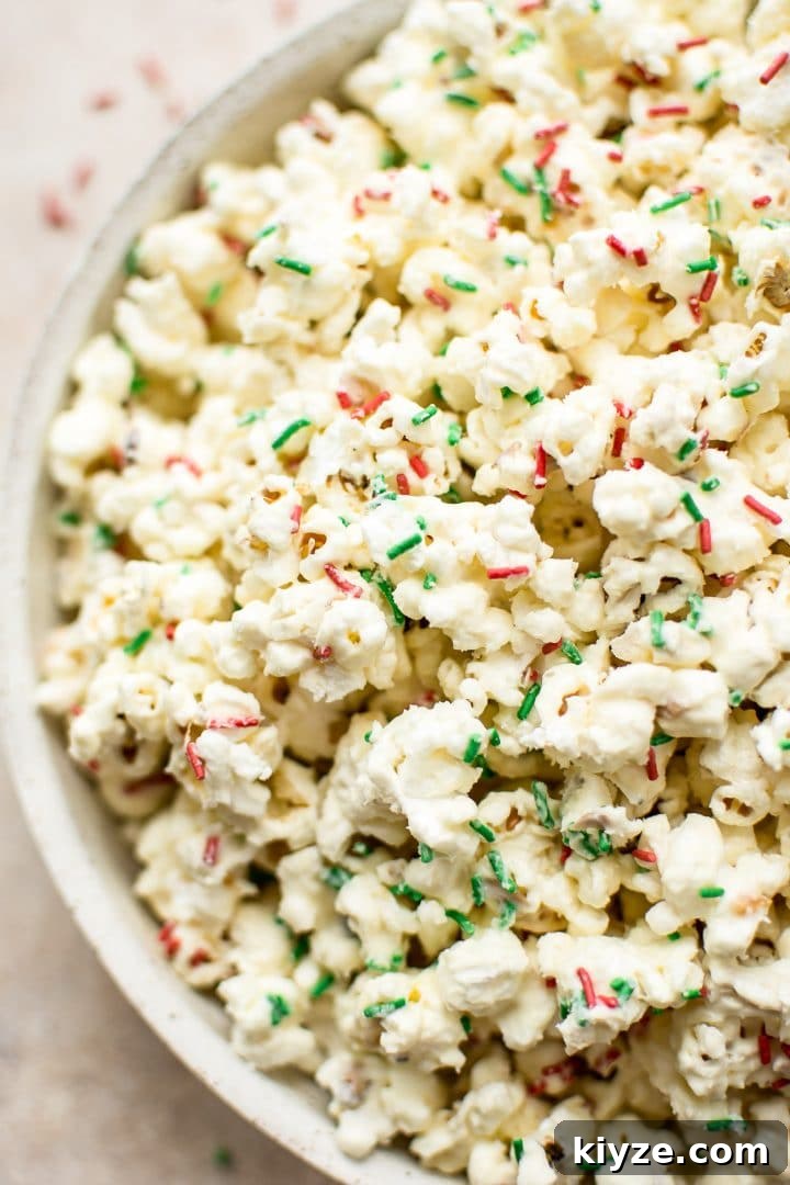 Festive Christmas Popcorn Recipe for Holiday Parties 5 close-up of a bowl of festive popcorn with red and green sprinkles and white chocolate
