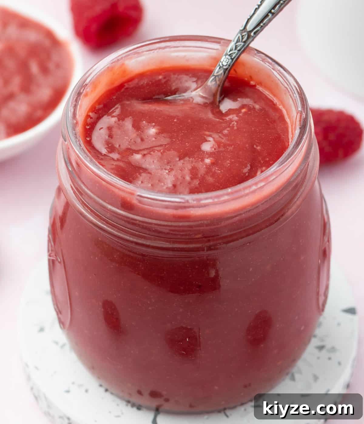 Close up on the curd placed inside a glass jar with a spoon.