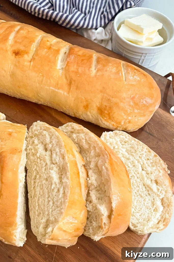 90-Minute Artisan French Bread Recipe for Crisp Crust and Soft Crumb 2 Easy 90 Minute French Bread on a cutting board. One loaf is sliced with a jar of butter in the background