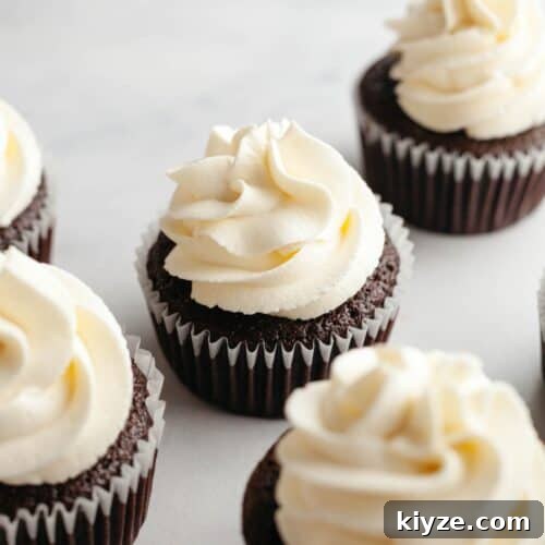 Cream cheese frosting piped onto chocolate cupcakes.