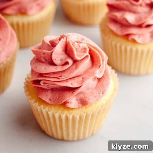 Vanilla cupcakes topped with pink raspberry frosting.