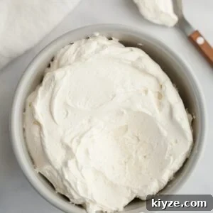 Mascarpone Whipped Cream Frosting Recipe — 5 Ingredients 15 A light grey bowl filled with mascarpone whipped cream frosting.