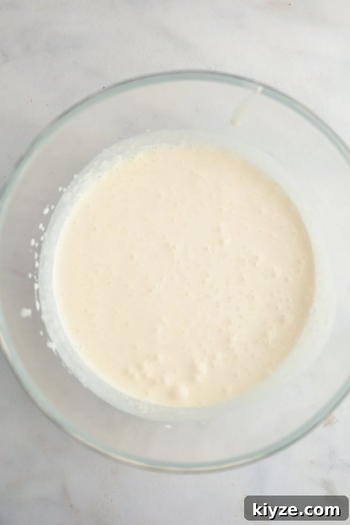 Mascarpone Whipped Cream Frosting Recipe — 5 Ingredients 4 A large glass bowl with heavy cream in it.