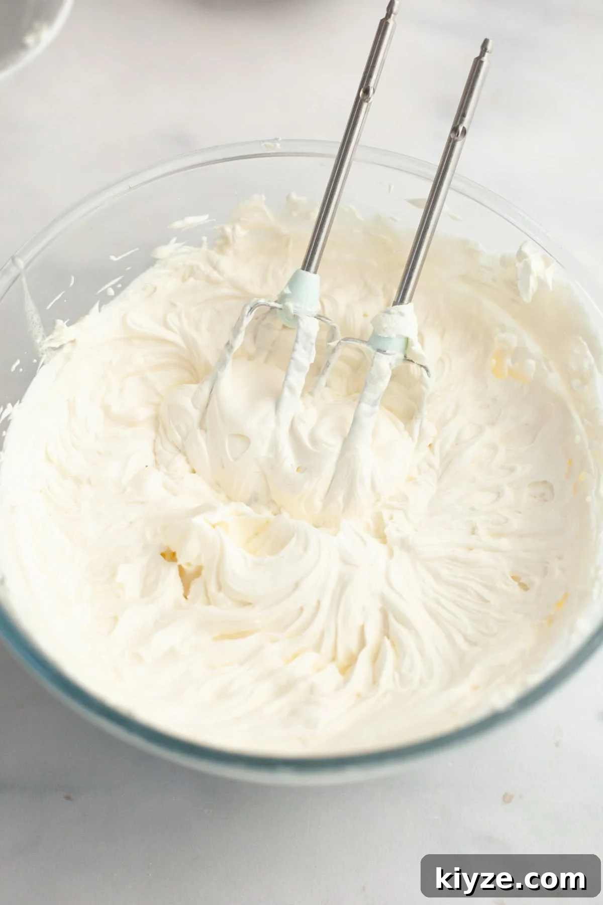 Mascarpone Whipped Cream Frosting Recipe — 5 Ingredients 6 A large glass bowl filled with mascarpone whipped cream frosting.
