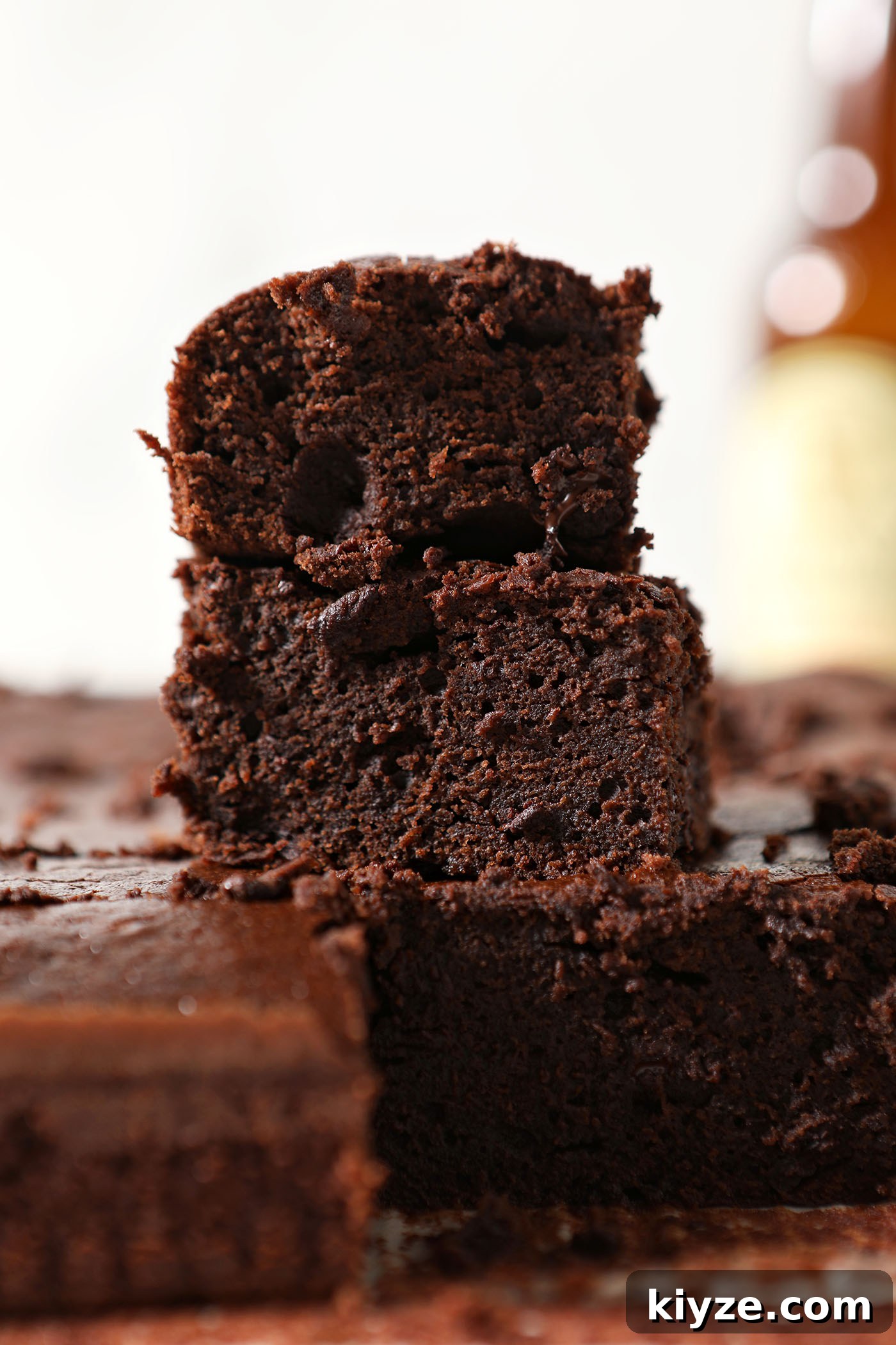 Decadent Guinness Chocolate Brownies: Rich Stout-Infused Recipe 6 Gooey brownies stacked on top of each other in front of a beer bottle