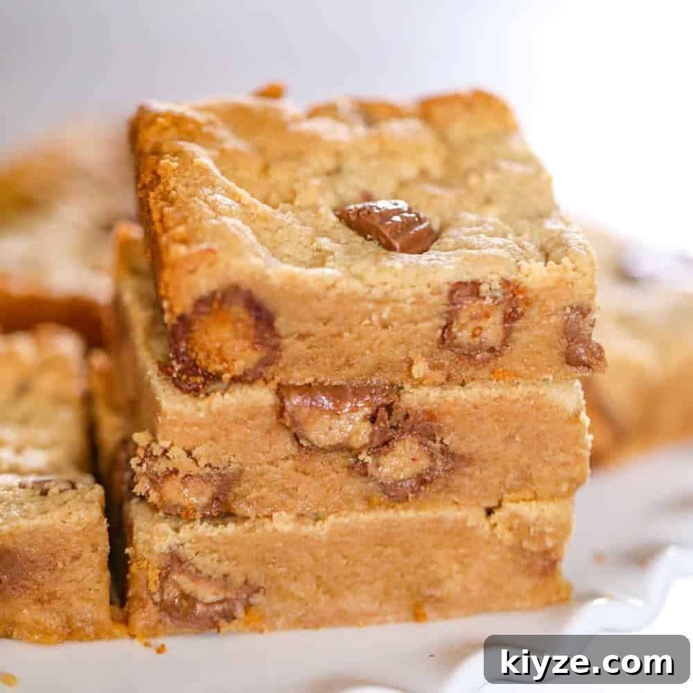 Peanut Butter Cup Blondies Recipe — Gooey Chocolate & Peanut Butter 2 peanut butter blondies in a stack