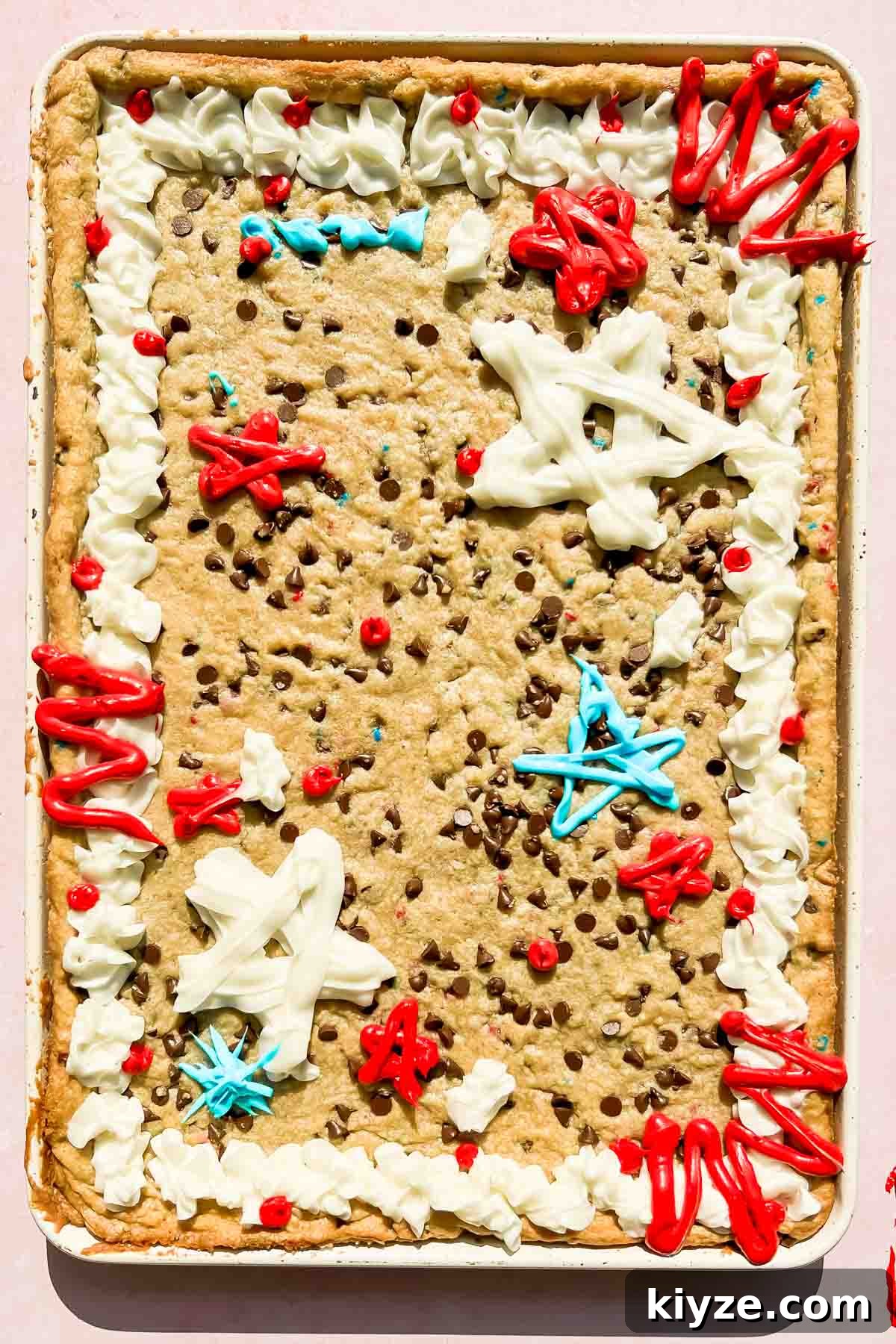 Fourth of July Flag Cookie Cake Recipe 11 fourth of july cookie cake decorated with red, white and blue frosting in white baking tray.
