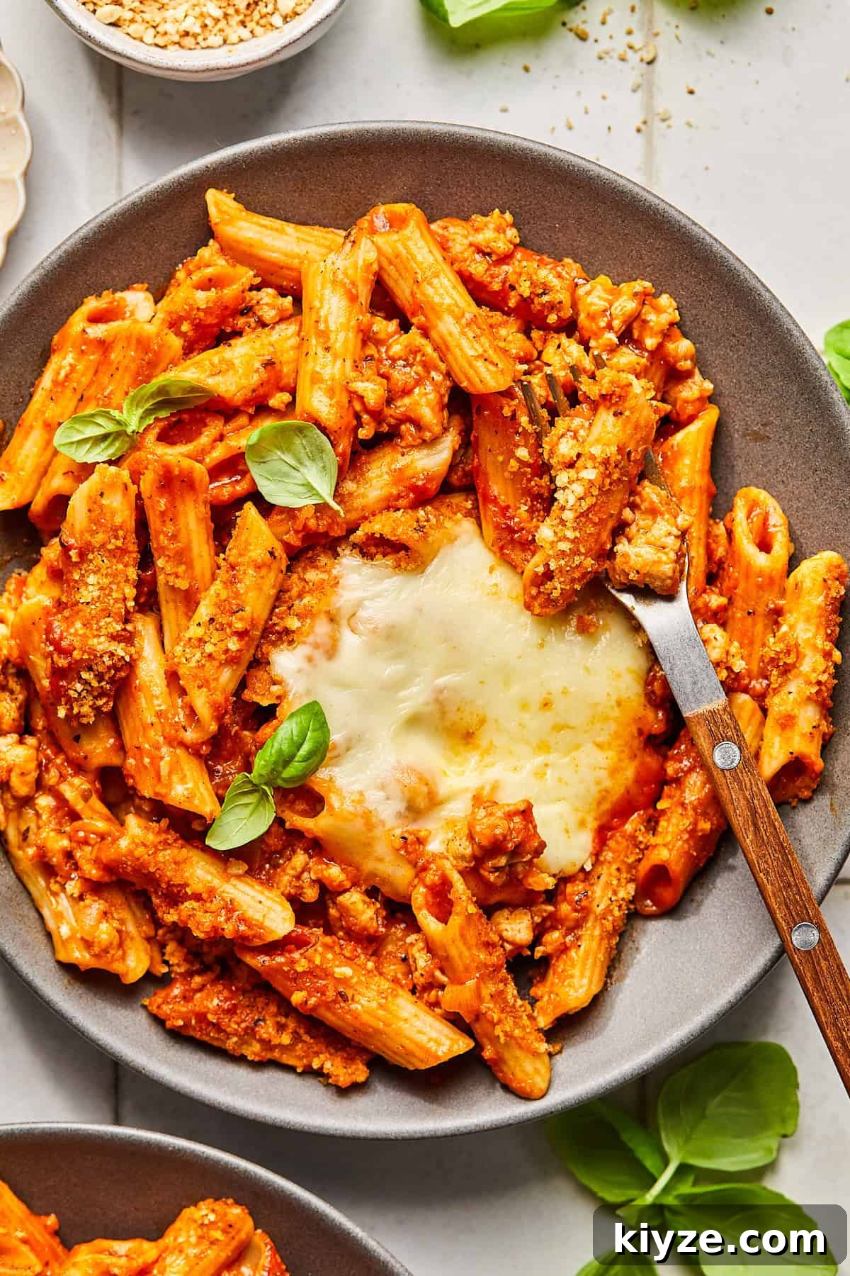 One-Pot Gluten-Free Chicken Parmesan Pasta Recipe 2 a plate of chicken parmesan pasta topped with basil