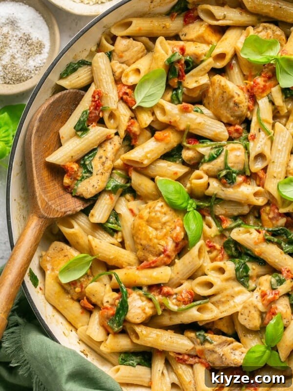 One-Pot Gluten-Free Chicken Parmesan Pasta Recipe 15 Marry me chicken pasta in a skillet with a wooden spoon