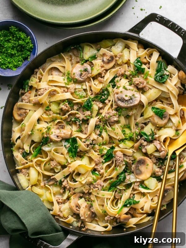 One-Pot Gluten-Free Chicken Parmesan Pasta Recipe 17 sausage and fennel pasta in a cast iron skillet with a green napkin next to it