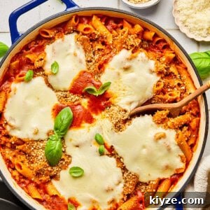 One-Pot Gluten-Free Chicken Parmesan Pasta Recipe 19 chicken parmesan pasta in a blue dutch oven surrounded by basil and ingredients