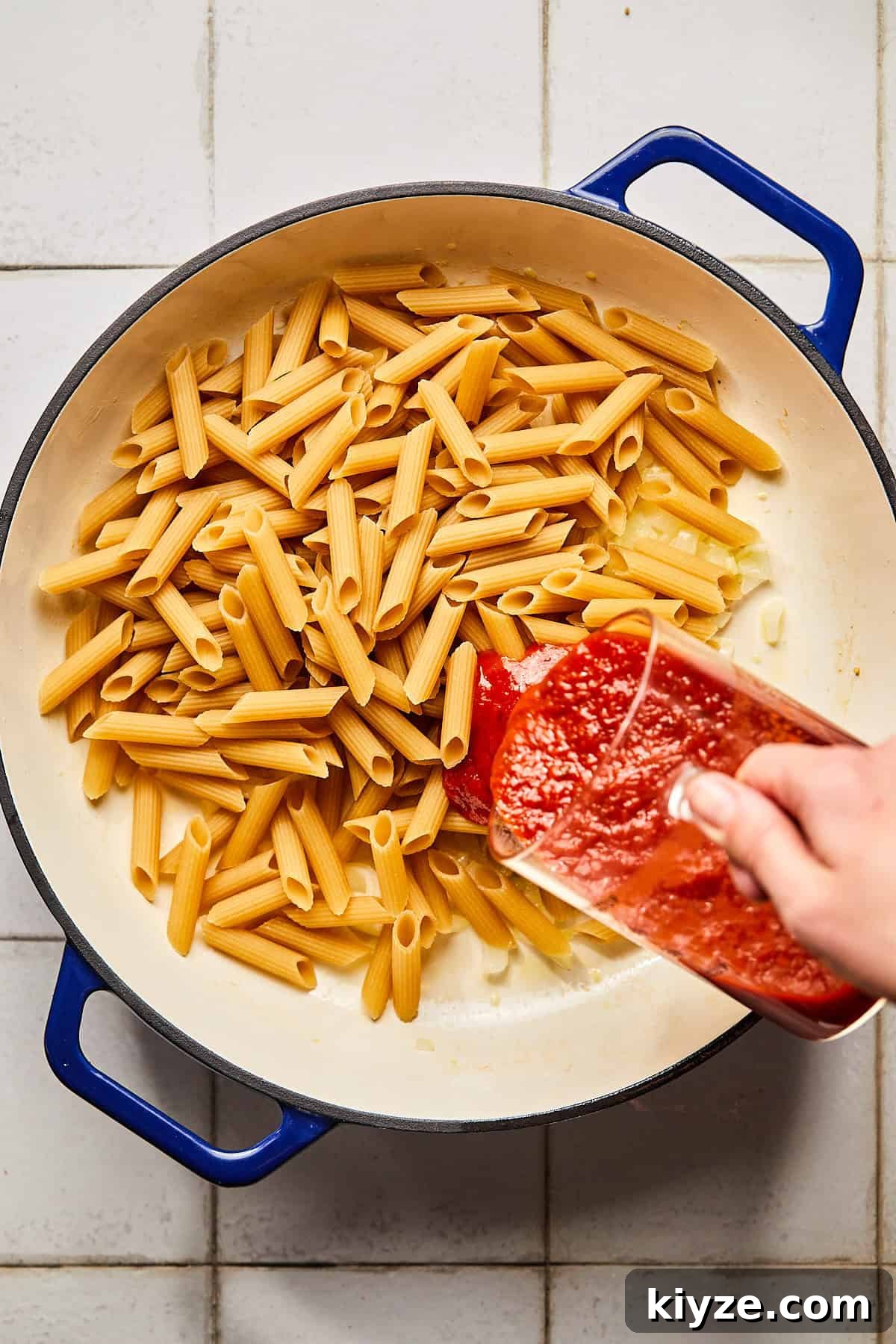 One-Pot Gluten-Free Chicken Parmesan Pasta Recipe 6 pasta in a pot with sauce being poured in