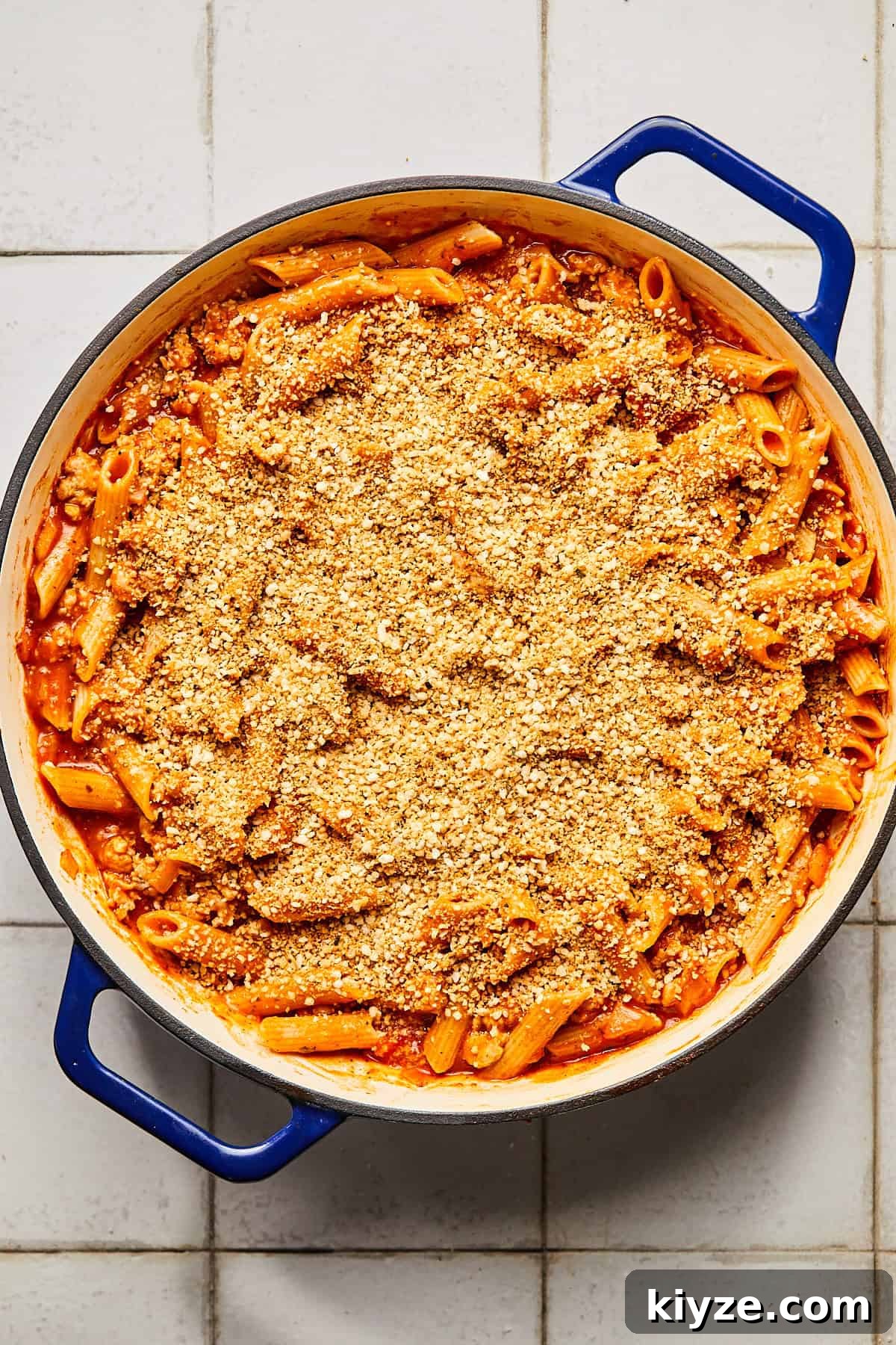 One-Pot Gluten-Free Chicken Parmesan Pasta Recipe 10 pasta with red sauce topped with breadcrumbs in a blue dutch oven
