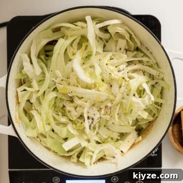 Savory Italian Cabbage with Garlic and Parmesan 10 Adding cabbage to the dutch oven.