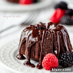 Mini Chocolate Bundt Pound Cakes: Rich Single-Serve Recipe 10 Small dessert plate with mini bundt chocolate pound cake drizzled with chocolate ganache and bowl of berries