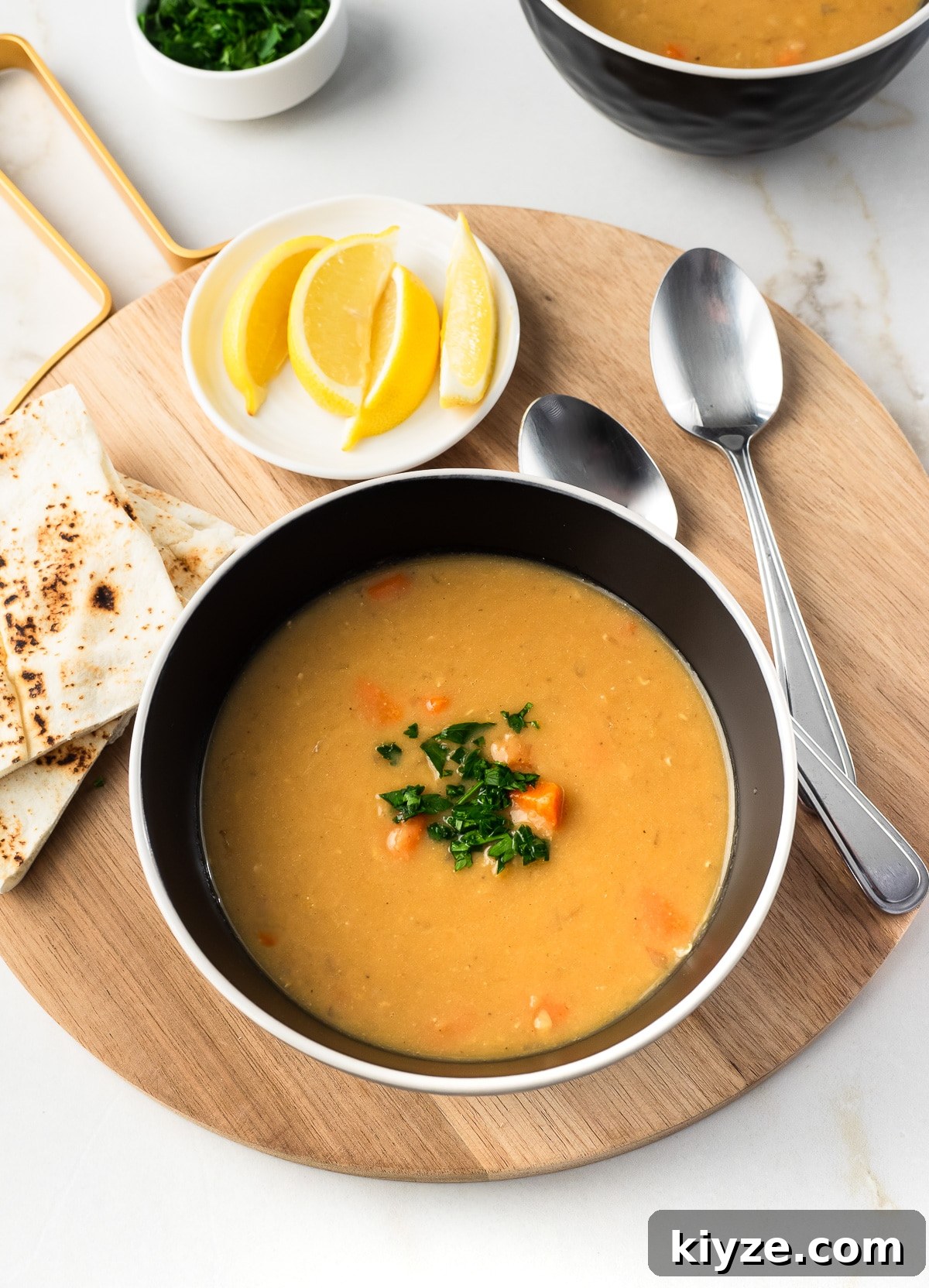Traditional Lebanese Red Lentil Soup Recipe 2 Bowl of red lentil soup topped with chopped parsley.