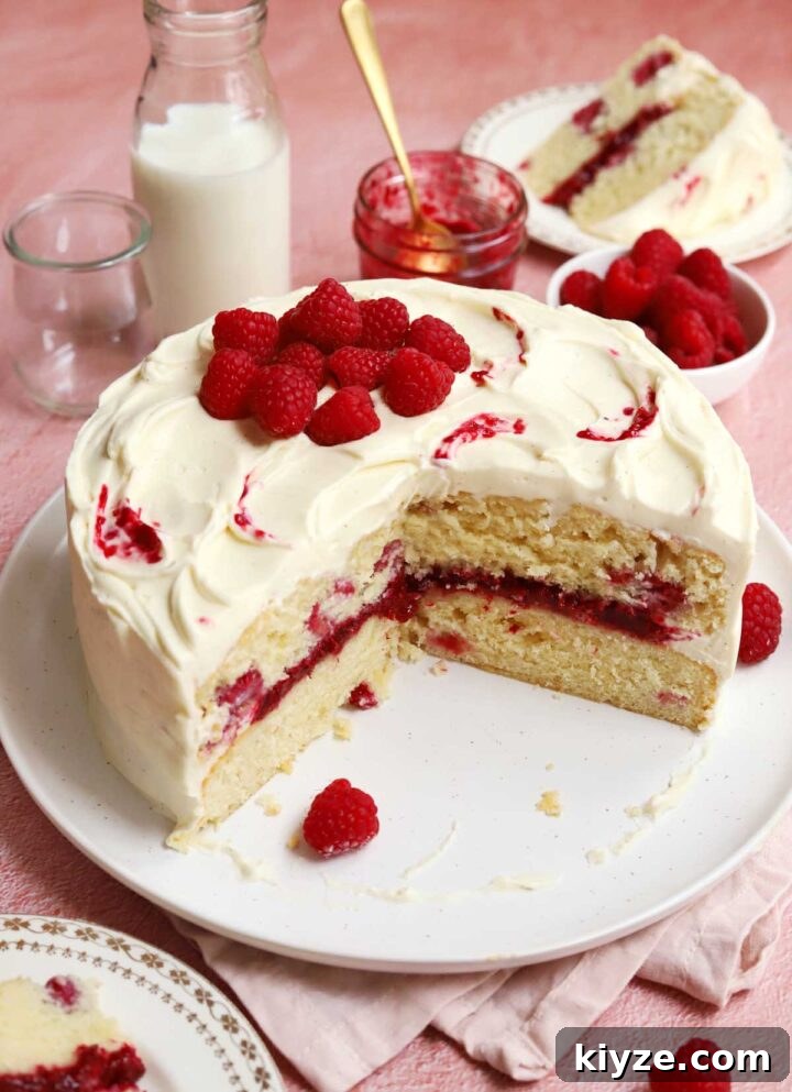 Decadent White Chocolate Raspberry Layer Cake Recipe 2 white chocolate raspberry cake sliced on serving plate