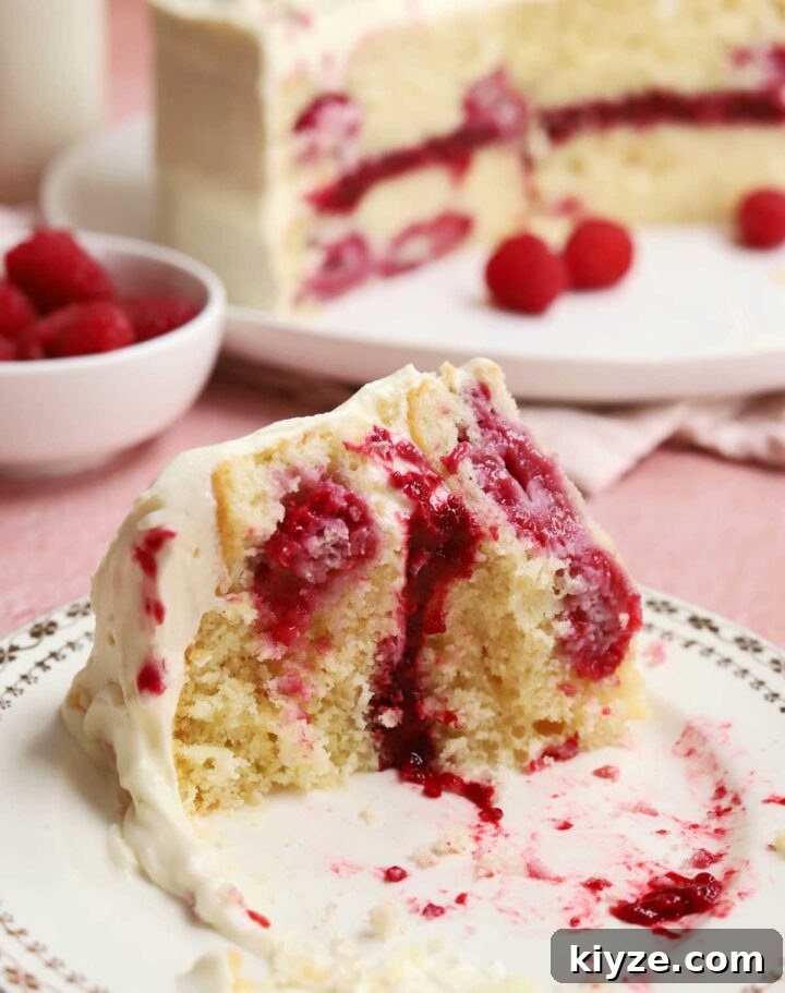 Decadent White Chocolate Raspberry Layer Cake Recipe 5 white chocolate raspberry cake slice with bite