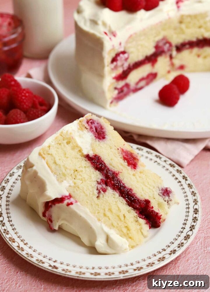 Decadent White Chocolate Raspberry Layer Cake Recipe 8 white chocolate raspberry cake slice on a plate