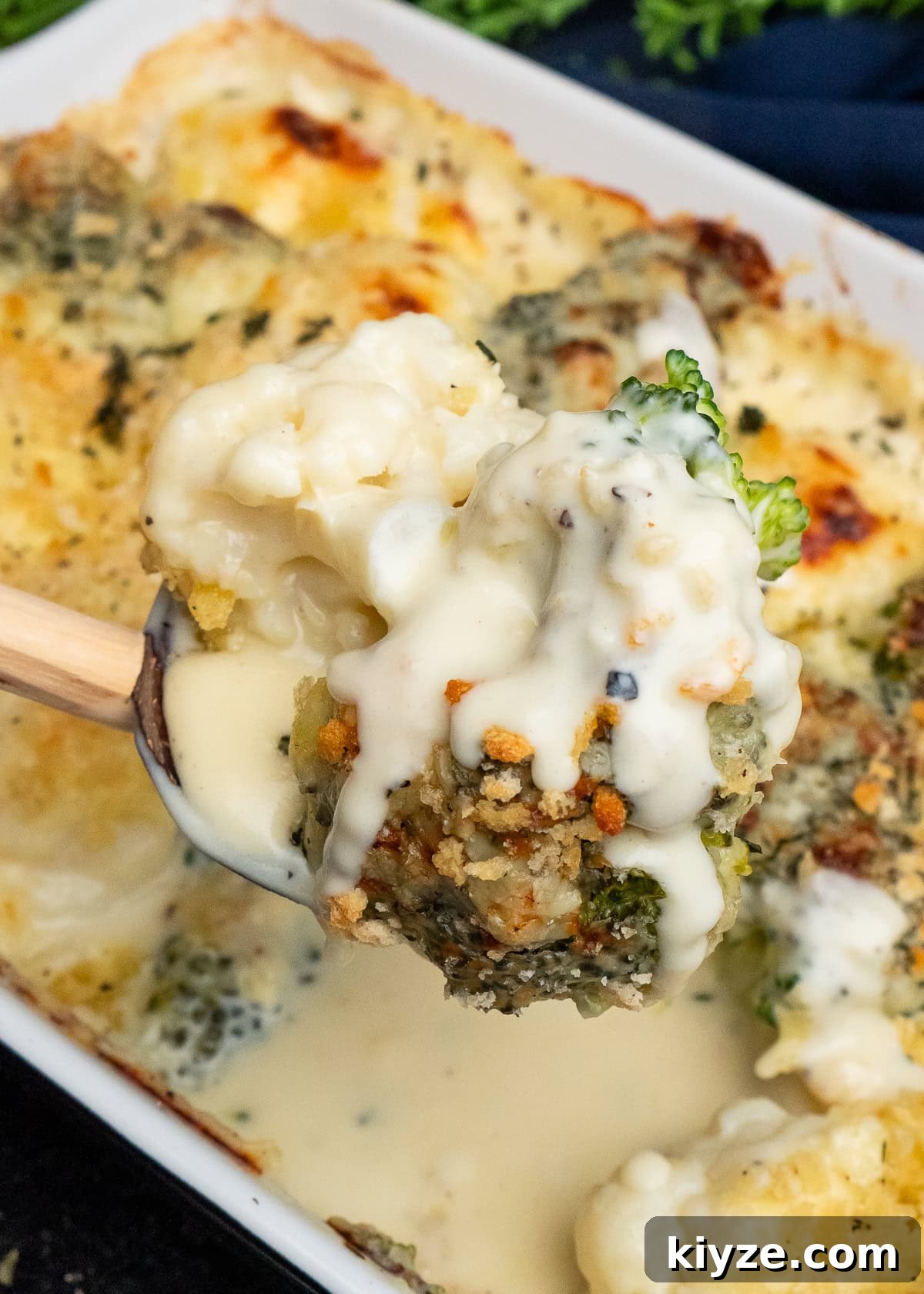 Cheesy Cauliflower and Broccoli Casserole Recipe 3 Cauliflower and Broccoli with melted cheese over the top being picked up with a spoon