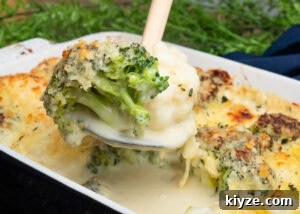 Cheesy Cauliflower and Broccoli Casserole Recipe 16 Cauliflower and Broccoli Cheese being picked up with a spoon with melted cheese sauce dripping down