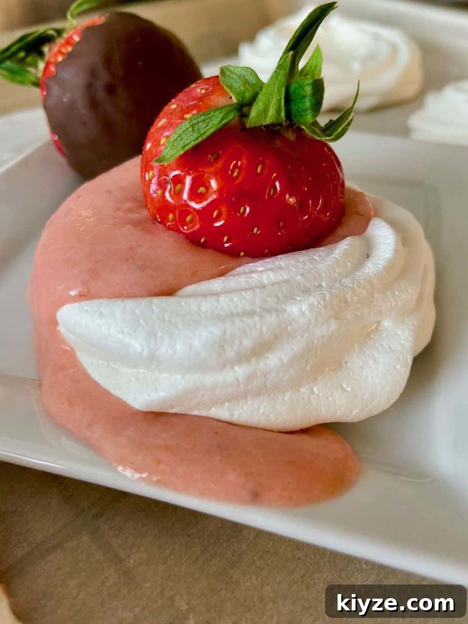 Strawberry Curd Pavlova with Whipped Cream and Fresh Berries 2 Mini pavlova with strawberry on plate.