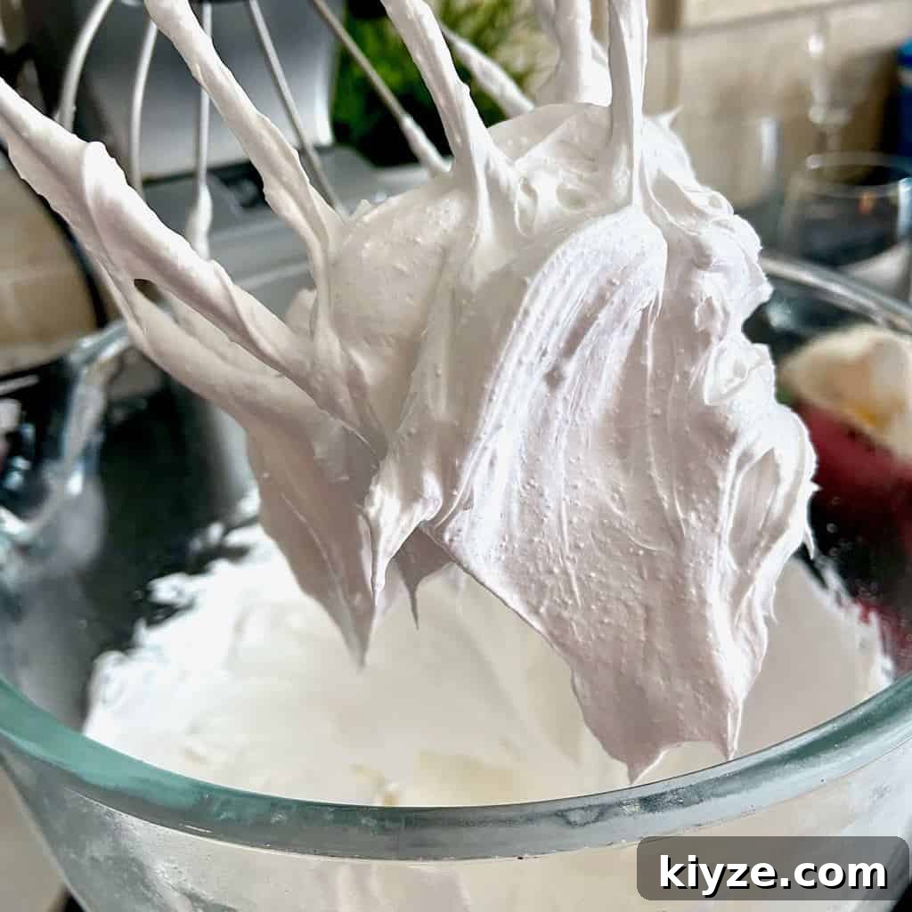Strawberry Curd Pavlova with Whipped Cream and Fresh Berries 3 Stiff peaks of egg whites on whisk attachment.