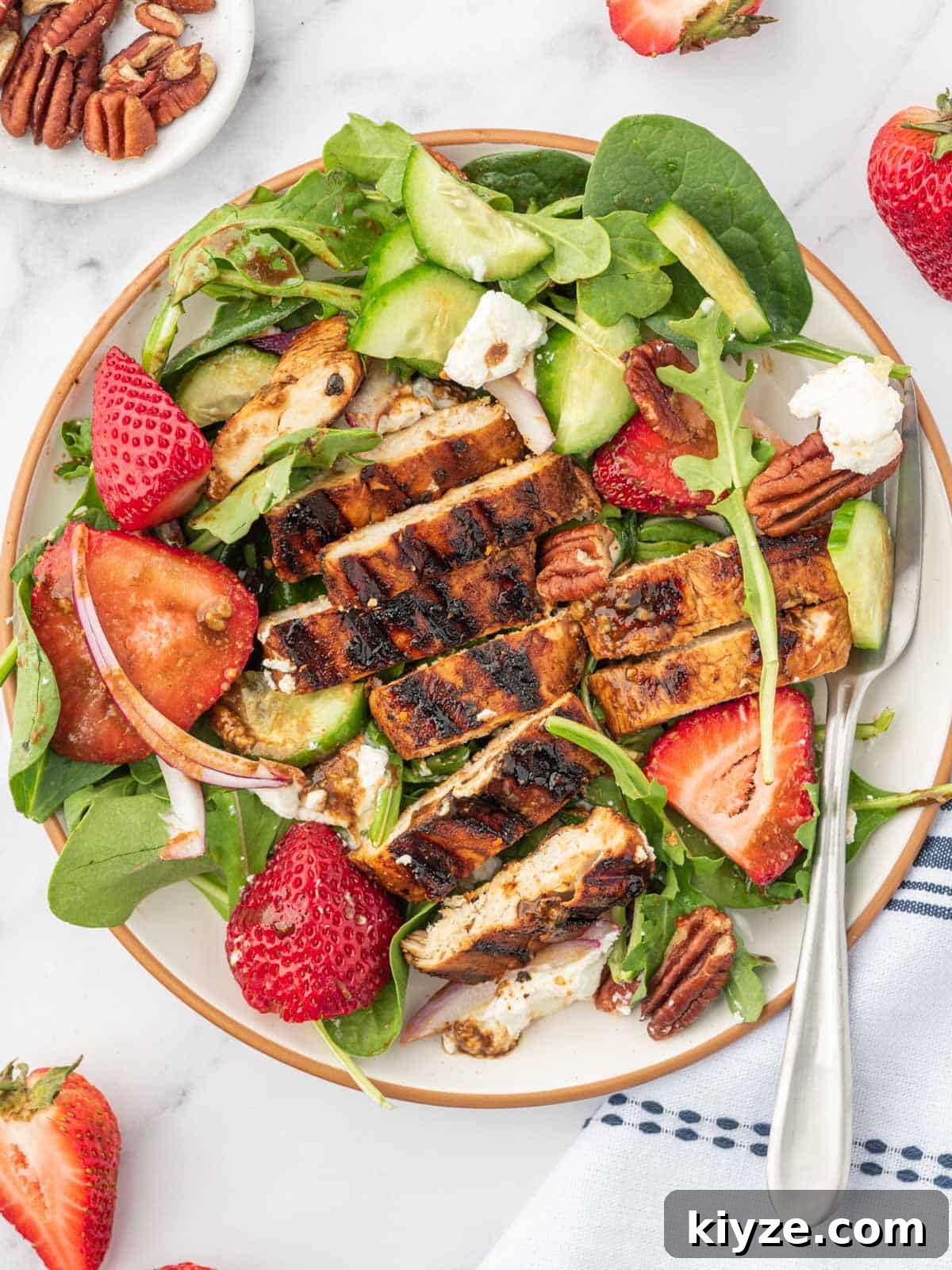 Grilled Chicken and Strawberry Salad with Balsamic Glaze 7 A serving plate of strawberry balsamic chicken salad with a fork.